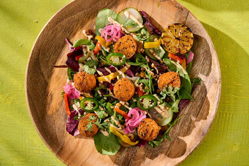 SAŁATKA Z FALAFELAMI I DRESSINGIEM TAHINI, PODAWANA ZE SCHIACCIATĄ